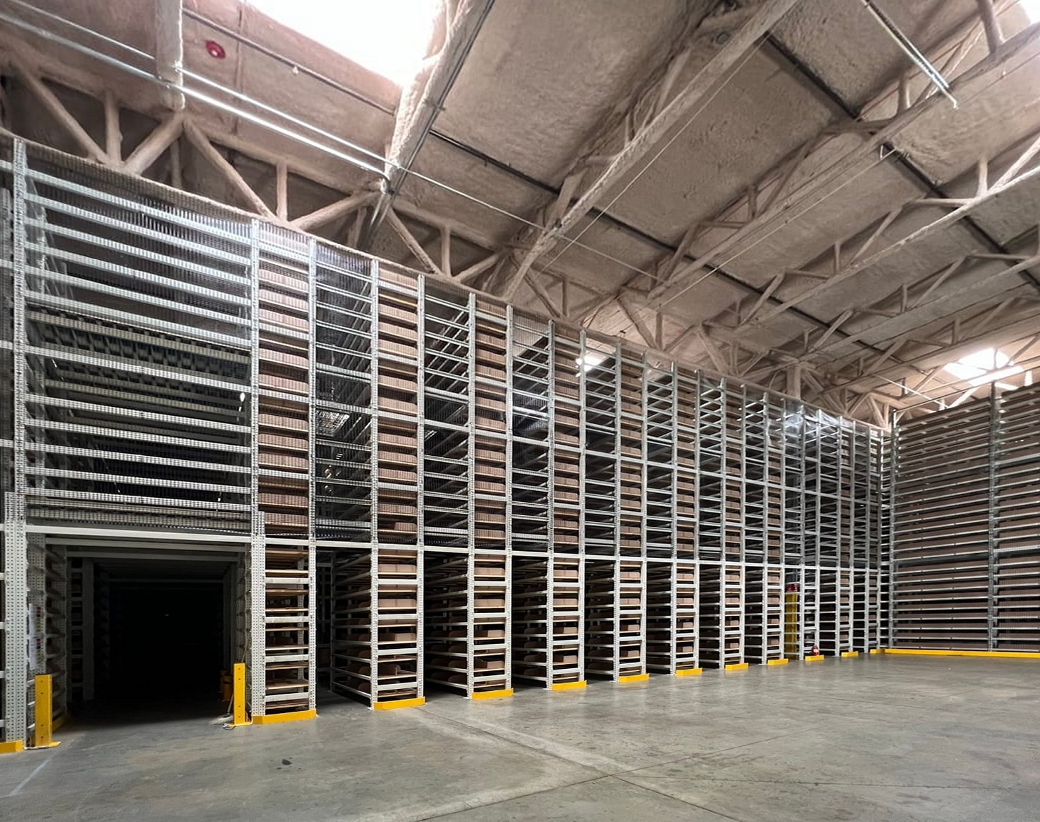 Bank of multi-tier tube rack file storage shelving reaching toward the roof deck of a Redlands, CA records facility
